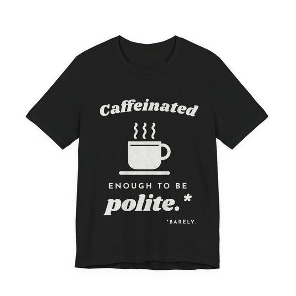 Black t-shirt printed in off-white ink with “Caffeinated” over a steaming coffee cup, then “Enough to Be polite.*” with a tiny footnote: “*Barely.”