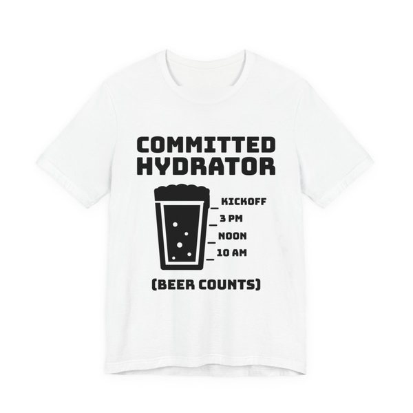 White t-shirt printed in dark ink with “Committed Hydrator” above a pint glass with fill lines marked 10 AM, Noon, 3 PM and Kickoff, and “(Beer Counts)”