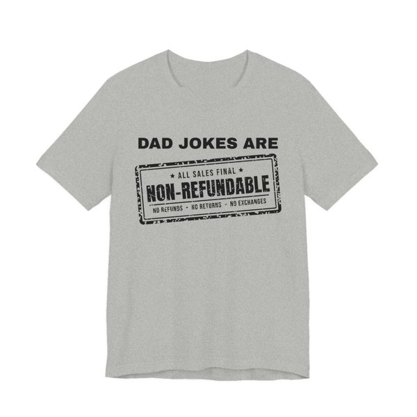 Athletic Heather t-shirt printed in dark ink with the words “Dad Jokes Are” above a distressed rubber stamp reading “Non-Refundable”