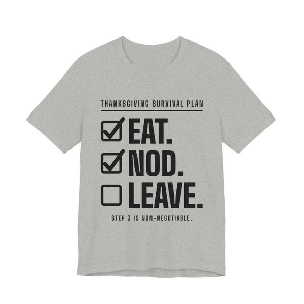 Athletic Heather t-shirt printed in dark ink with a “Thanksgiving Survival Plan” checklist: Eat. (checked), Nod. (checked), Leave. (not yet), with “Step 3 is non-negotiable”