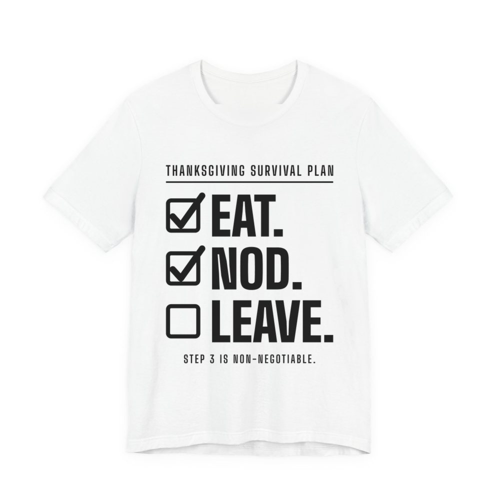 White t-shirt printed in dark ink with a “Thanksgiving Survival Plan” checklist: Eat. (checked), Nod. (checked), Leave. (not yet), with “Step 3 is non-negotiable”