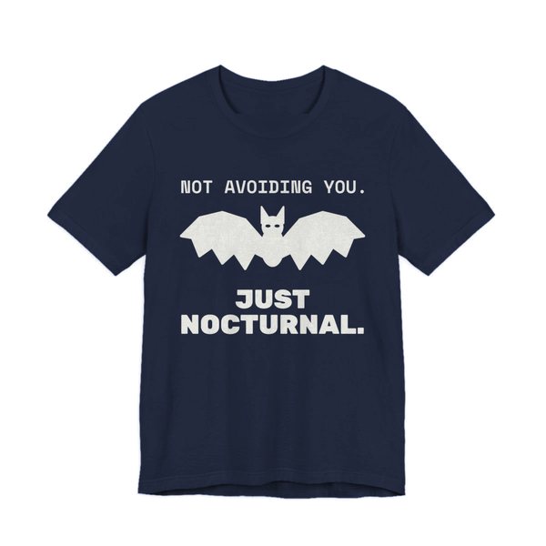 Navy t-shirt printed in off-white ink with “Not Avoiding You.” above a bat with wings spread, then “Just Nocturnal.”