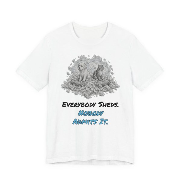 White t-shirt printed in full-color print with a full-color pencil drawing of a puppy and a kitten sitting in a pile of fur and the words “Everybody Sheds. Nobody Admits It.”