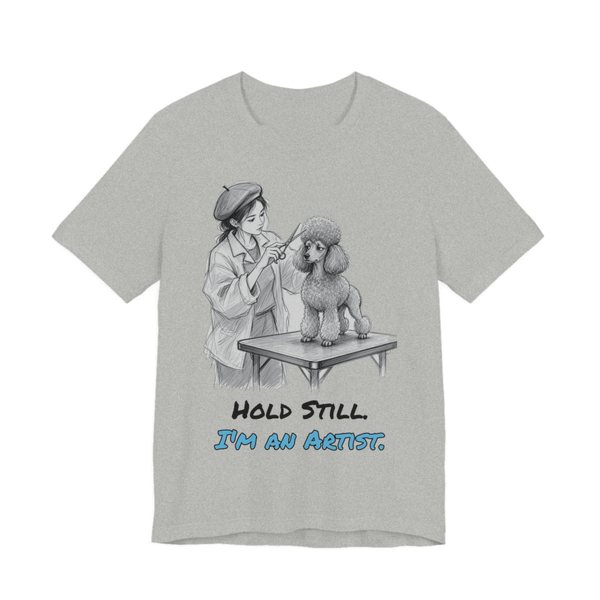 Athletic Heather t-shirt printed in full-color print with a full-color pencil drawing of a groomer in a beret sculpting a poodle cut and the words “Hold Still. I'm an Artist.”