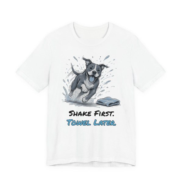 White t-shirt printed in full-color print with a full-color pencil drawing of a pit bull shaking off water next to a towel and the words “Shake First. Towel Later.”