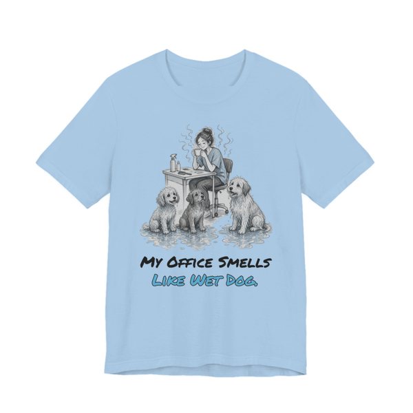 Baby Blue t-shirt printed in full-color print with a full-color pencil drawing of a groomer at a desk surrounded by wet dogs and the words “My Office Smells Like Wet Dog.”