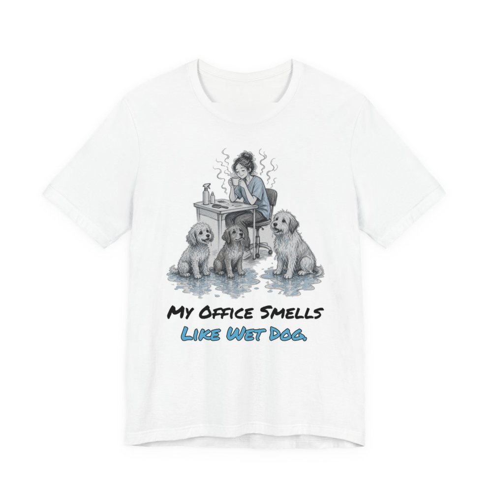 White t-shirt printed in full-color print with a full-color pencil drawing of a groomer at a desk surrounded by wet dogs and the words “My Office Smells Like Wet Dog.”