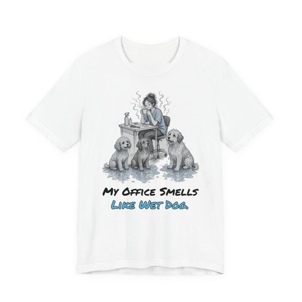 White t-shirt printed in full-color print with a full-color pencil drawing of a groomer at a desk surrounded by wet dogs and the words “My Office Smells Like Wet Dog.”