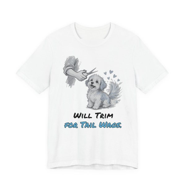 White t-shirt printed in full-color print with a full-color pencil drawing of a small fluffy dog getting a trim, with little hearts and the words “Will Trim for Tail Wags.”