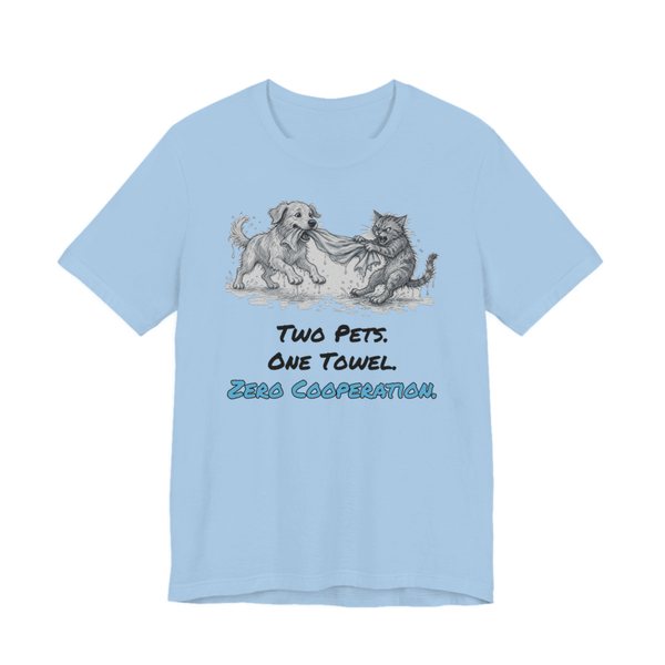 Baby Blue t-shirt printed in full-color print with a full-color pencil drawing of a dog and a cat tugging on the same towel and the words “Two Pets. One Towel. Zero Cooperation.”