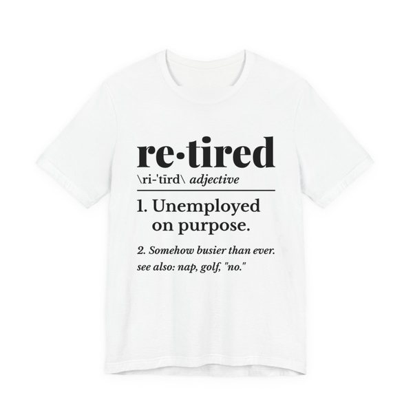 White t-shirt printed in dark ink with a dictionary entry: “re·tired, adjective. 1. Unemployed on purpose. 2. Somehow busier than ever. See also: nap, golf, “no.””