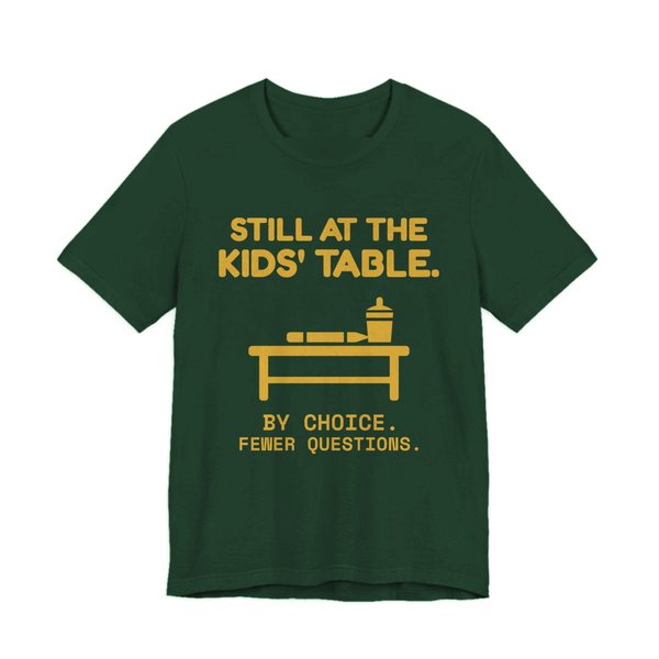 Forest t-shirt printed in gold ink with the words “Still at the Kids' Table.”