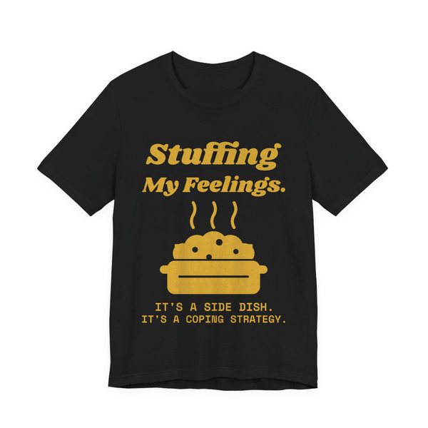 Black t-shirt printed in gold ink with the words “Stuffing My Feelings.”