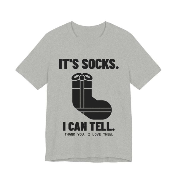 Athletic Heather t-shirt printed in dark ink with a sock-shaped wrapped present and the words “It's Socks. I Can Tell. Thank you. I love them.”