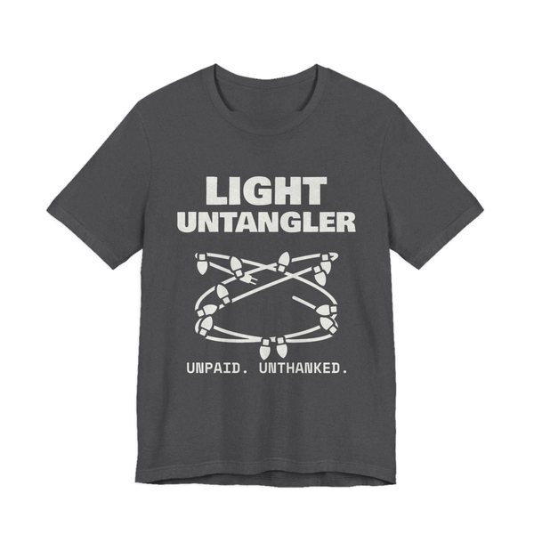 Dark Grey Heather t-shirt printed in off-white ink with a hopelessly tangled string of Christmas lights and the words “Light Untangler. Unpaid. Unthanked.”