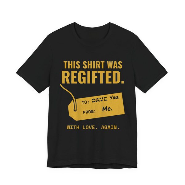 Black t-shirt printed in gold ink with a gift tag with “Dave” crossed out for “You” and the words “This Shirt Was Regifted. With Love. Again.”