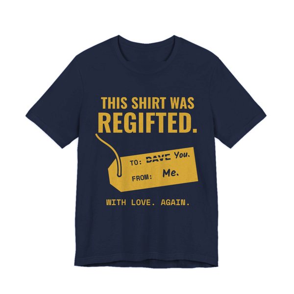Navy t-shirt printed in gold ink with a gift tag with “Dave” crossed out for “You” and the words “This Shirt Was Regifted. With Love. Again.”