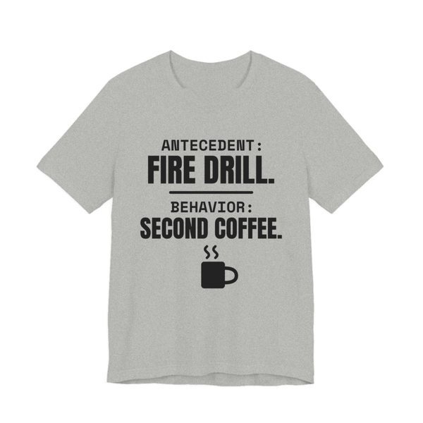 Athletic Heather t-shirt printed in dark ink with a steaming mug and the words “Antecedent: Fire Drill. Behavior: Second Coffee.”