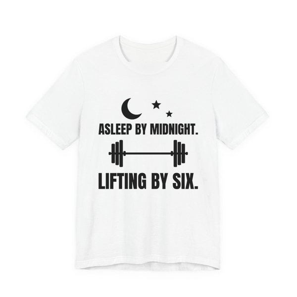 White t-shirt printed in dark ink with a moon and stars, a barbell and the words “Asleep by Midnight. Lifting by Six.”