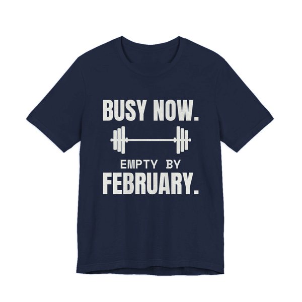 Navy t-shirt printed in off-white ink with a barbell and the words “Busy Now. Empty by February.”
