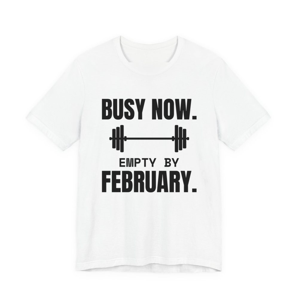 White t-shirt printed in dark ink with a barbell and the words “Busy Now. Empty by February.”