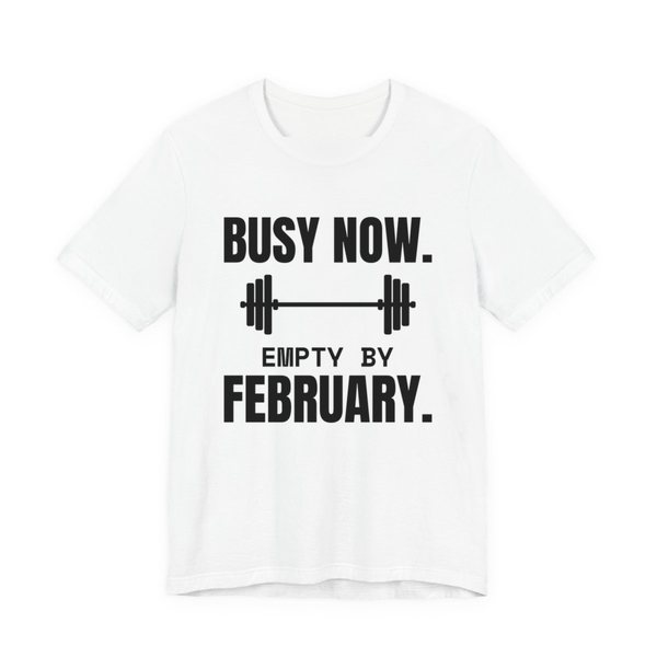 White t-shirt printed in dark ink with a barbell and the words “Busy Now. Empty by February.”