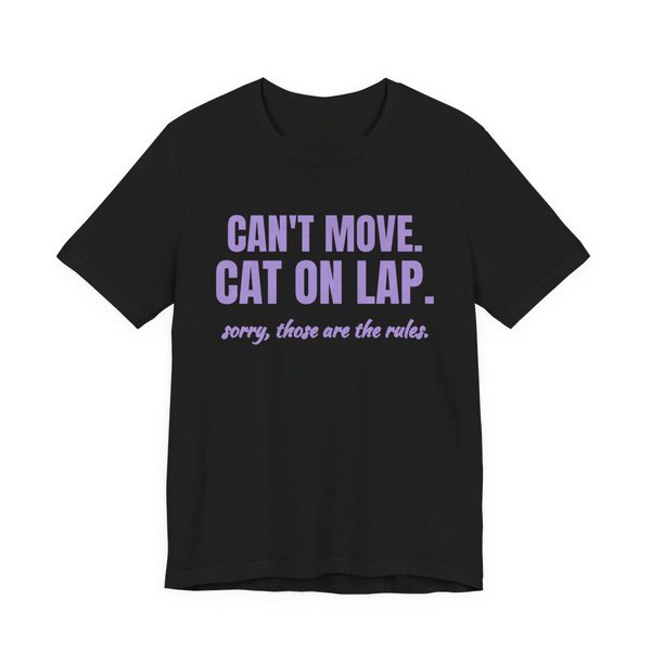 Black t-shirt printed in lavender ink with the words “Can't Move. Cat on Lap.”