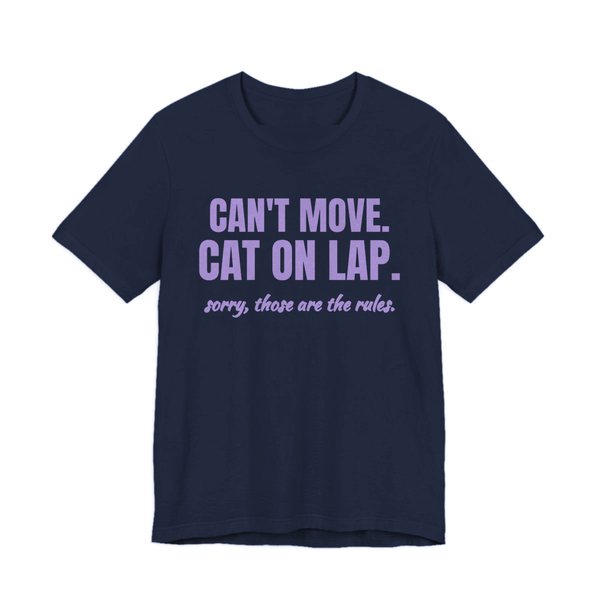 Navy t-shirt printed in lavender ink with the words “Can't Move. Cat on Lap.”