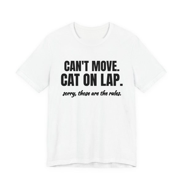 White t-shirt printed in dark ink with the words “Can't Move. Cat on Lap.”