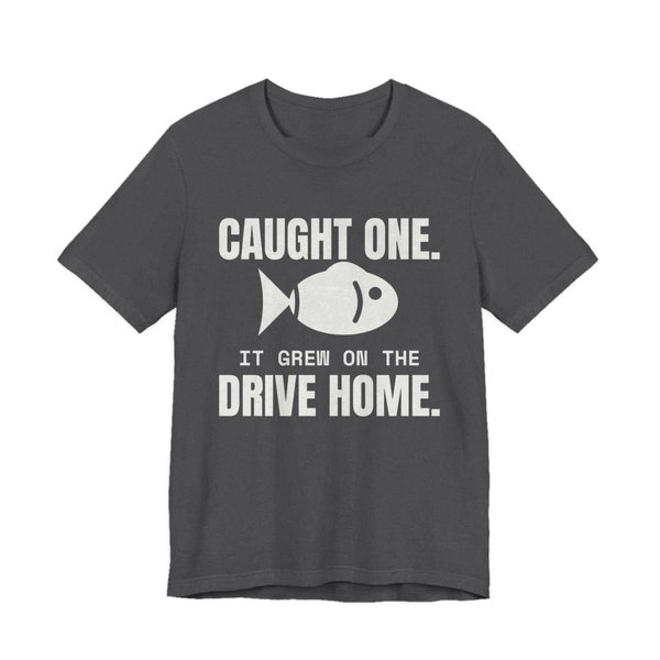 Dark Grey Heather t-shirt printed in off-white ink with a fish and the words “Caught One. It Grew on the Drive Home.”