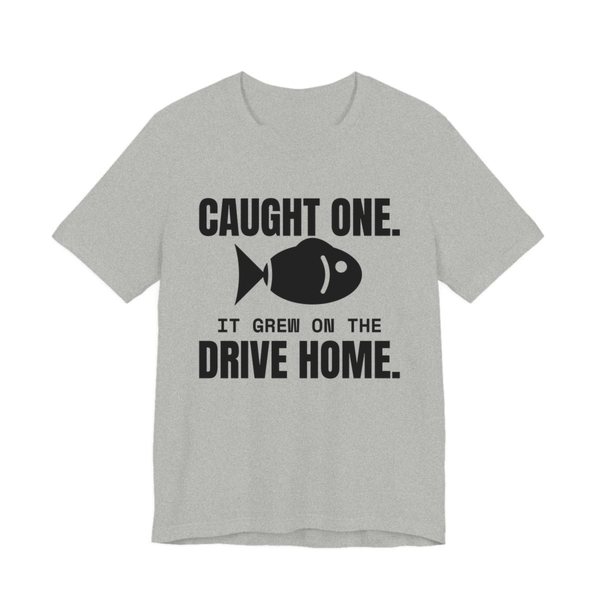 Athletic Heather t-shirt printed in dark ink with a fish and the words “Caught One. It Grew on the Drive Home.”