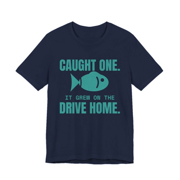 Navy t-shirt printed in teal ink with a fish and the words “Caught One. It Grew on the Drive Home.”