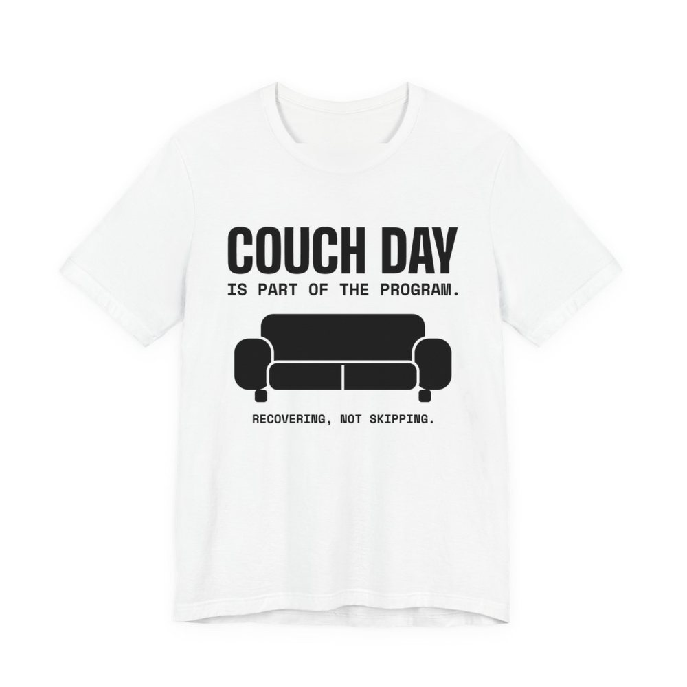 White t-shirt printed in dark ink with a couch and the words “Couch Day Is Part of the Program. Recovering, Not Skipping.”