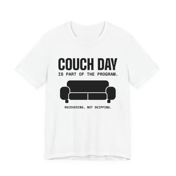 White t-shirt printed in dark ink with a couch and the words “Couch Day Is Part of the Program. Recovering, Not Skipping.”