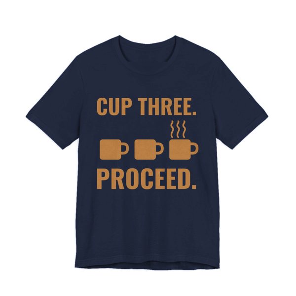 Navy t-shirt printed in caramel ink with a row of mugs, the last one steaming, and the words “Cup Three. Proceed.”