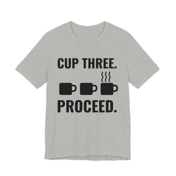 Athletic Heather t-shirt printed in dark ink with a row of mugs, the last one steaming, and the words “Cup Three. Proceed.”