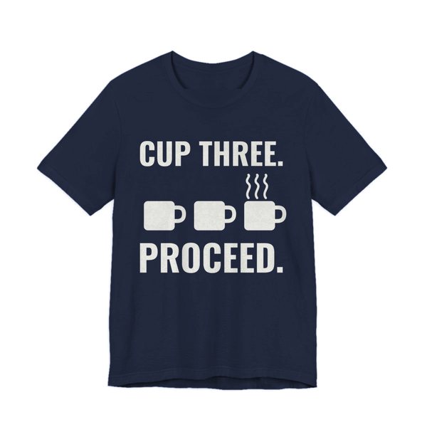 Navy t-shirt printed in off-white ink with a row of mugs, the last one steaming, and the words “Cup Three. Proceed.”