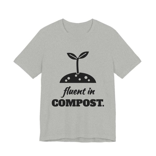 Athletic Heather t-shirt printed in dark ink with a sprout in a mound of soil and the words “Fluent in Compost.”