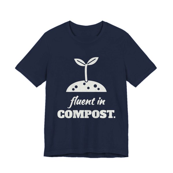 Navy t-shirt printed in off-white ink with a sprout in a mound of soil and the words “Fluent in Compost.”