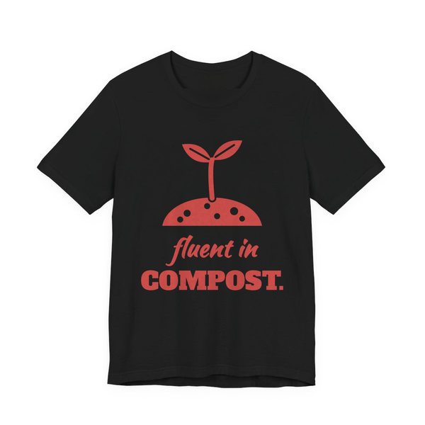 Black t-shirt printed in tomato red ink with a sprout in a mound of soil and the words “Fluent in Compost.”