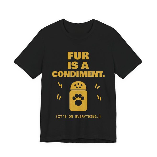 Black t-shirt printed in gold ink with a shaker with a paw print and the words “Fur Is a Condiment. (It's on everything.)”
