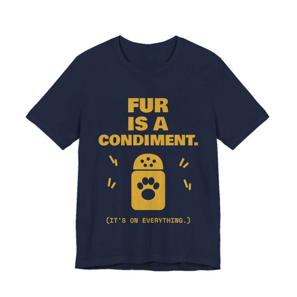 Navy t-shirt printed in gold ink with a shaker with a paw print and the words “Fur Is a Condiment. (It's on everything.)”
