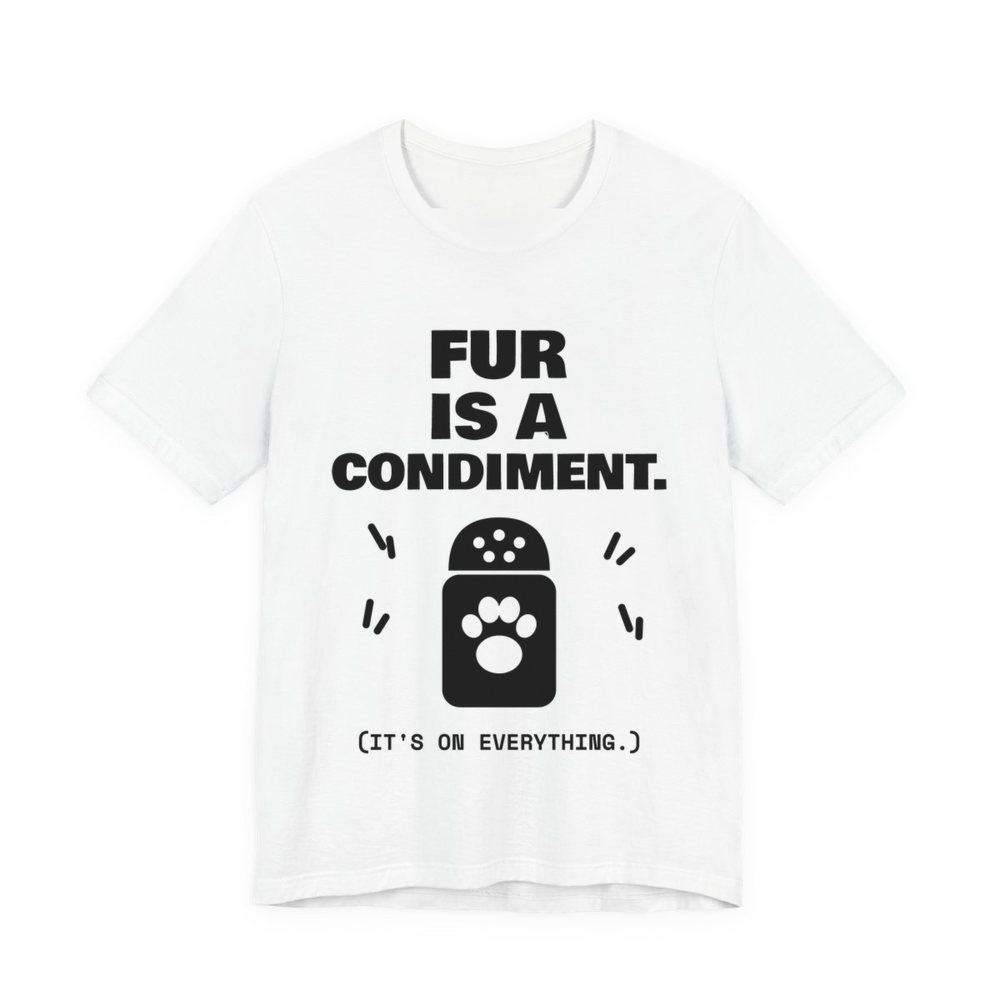 White t-shirt printed in dark ink with a shaker with a paw print and the words “Fur Is a Condiment. (It's on everything.)”