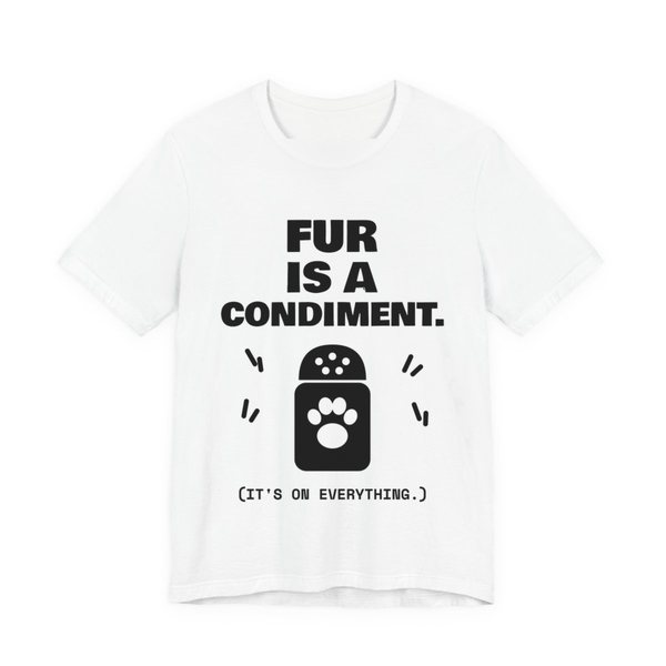 White t-shirt printed in dark ink with a shaker with a paw print and the words “Fur Is a Condiment. (It's on everything.)”