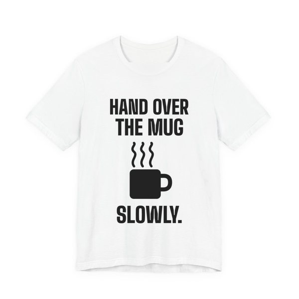 White t-shirt printed in dark ink with a steaming mug and the words “Hand Over the Mug Slowly.”