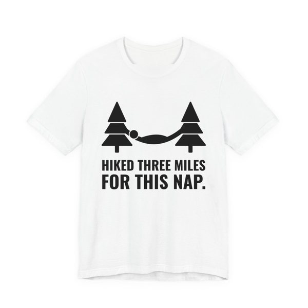 White t-shirt printed in dark ink with a hammock between two pine trees and the words “Hiked Three Miles for This Nap.”