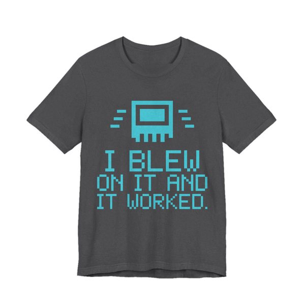 Dark Grey Heather t-shirt printed in cyan ink with a pixel-art cartridge and the words “I Blew on It and It Worked.” in a blocky pixel font