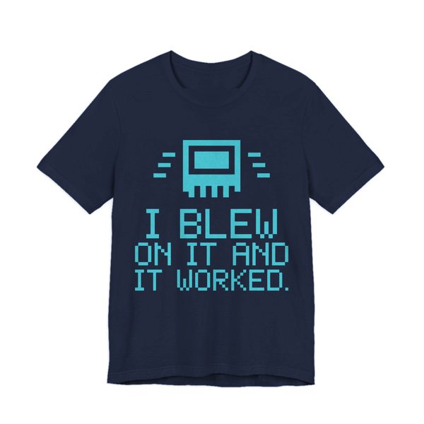 Navy t-shirt printed in cyan ink with a pixel-art cartridge and the words “I Blew on It and It Worked.” in a blocky pixel font