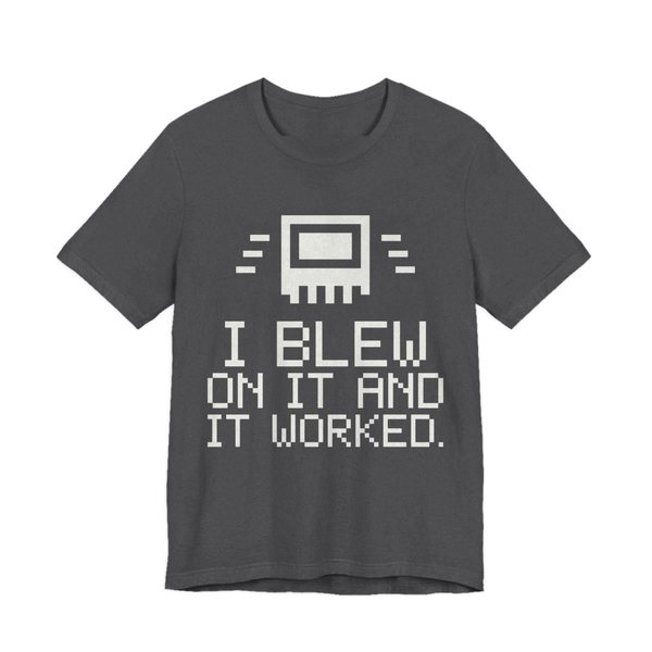 Dark Grey Heather t-shirt printed in off-white ink with a pixel-art cartridge and the words “I Blew on It and It Worked.” in a blocky pixel font