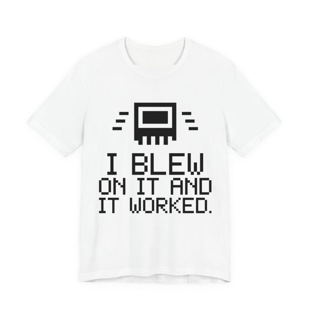 White t-shirt printed in dark ink with a pixel-art cartridge and the words “I Blew on It and It Worked.” in a blocky pixel font